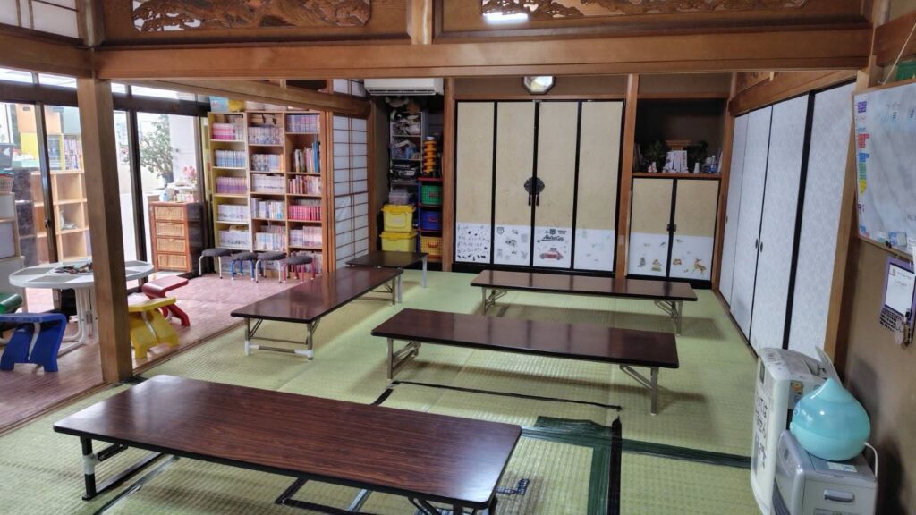 さくら児童クラブの室内。畳の和室に学習机が並び、本棚のあるあたたかな学びの空間